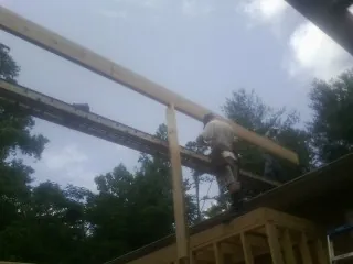 Carpenter setting a ridge beam over a new addition frame — Ice Dam Removal by Roofing Brothers in Clover