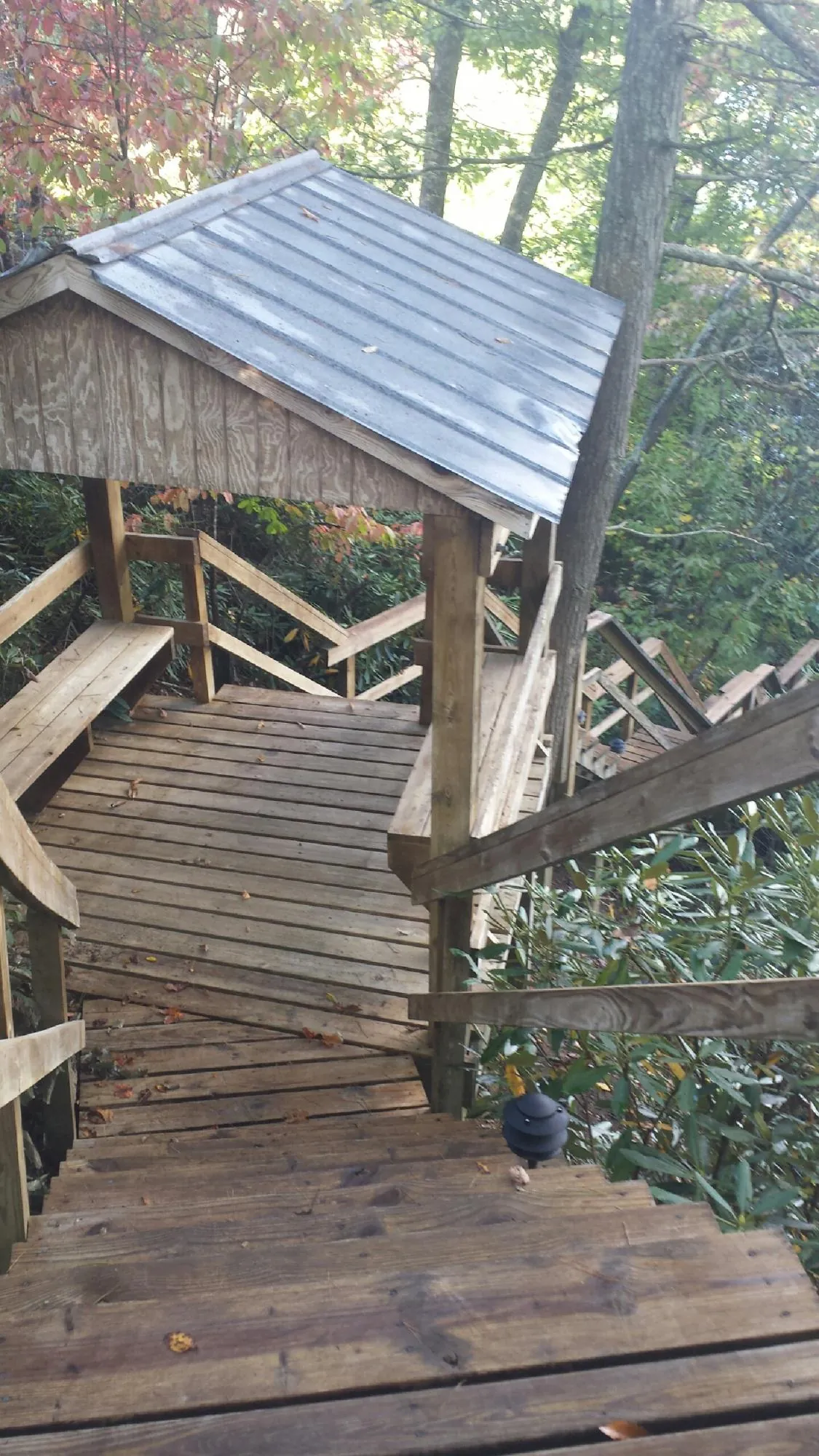 Metal roofed shelter over wooden steps on a wooded walkway — Skylight Repair & Installation work by our crew in Clover