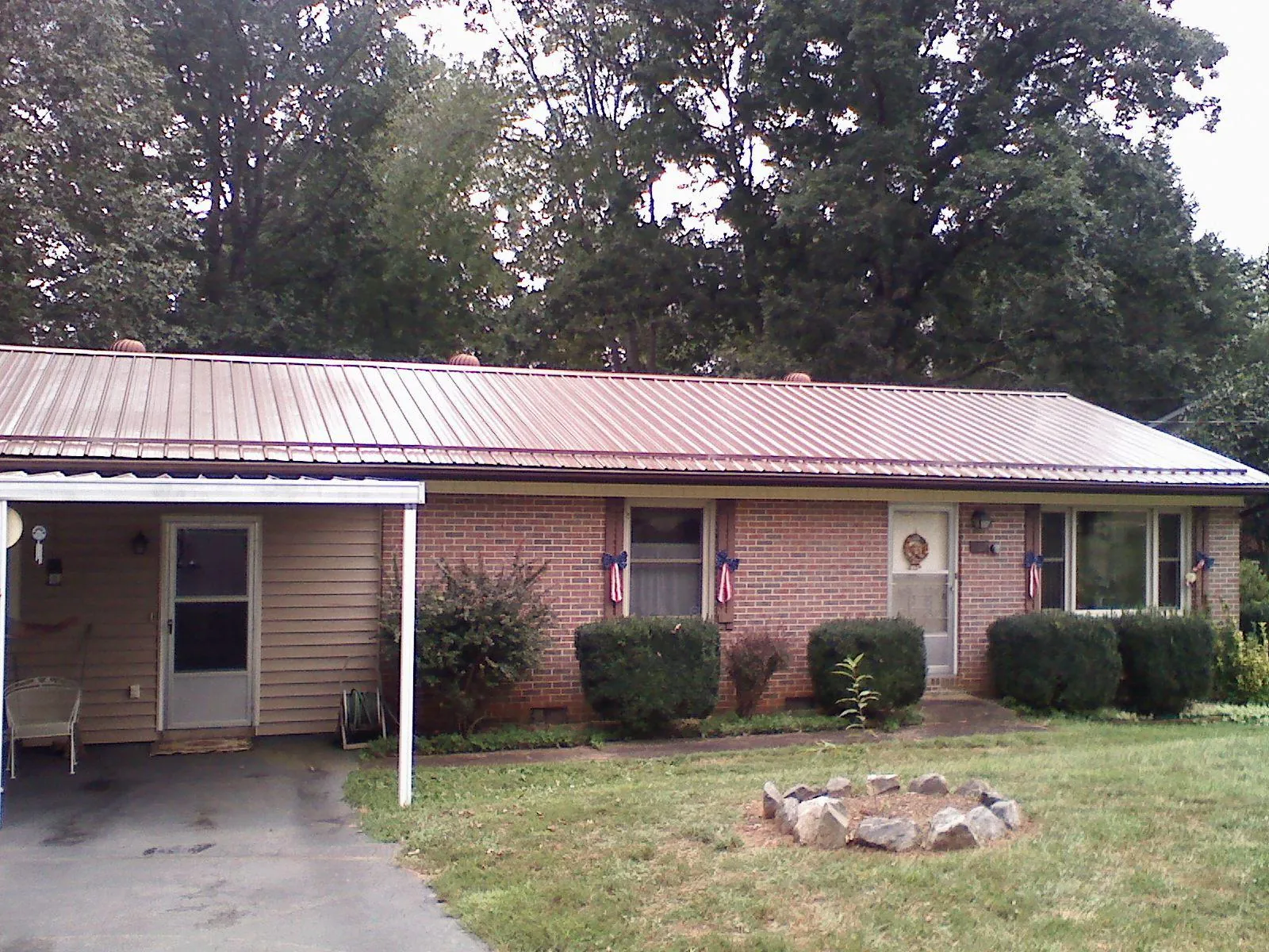 Bronze metal roof and carport on a brick ranch home — Roof Repair work by our crew in Clover