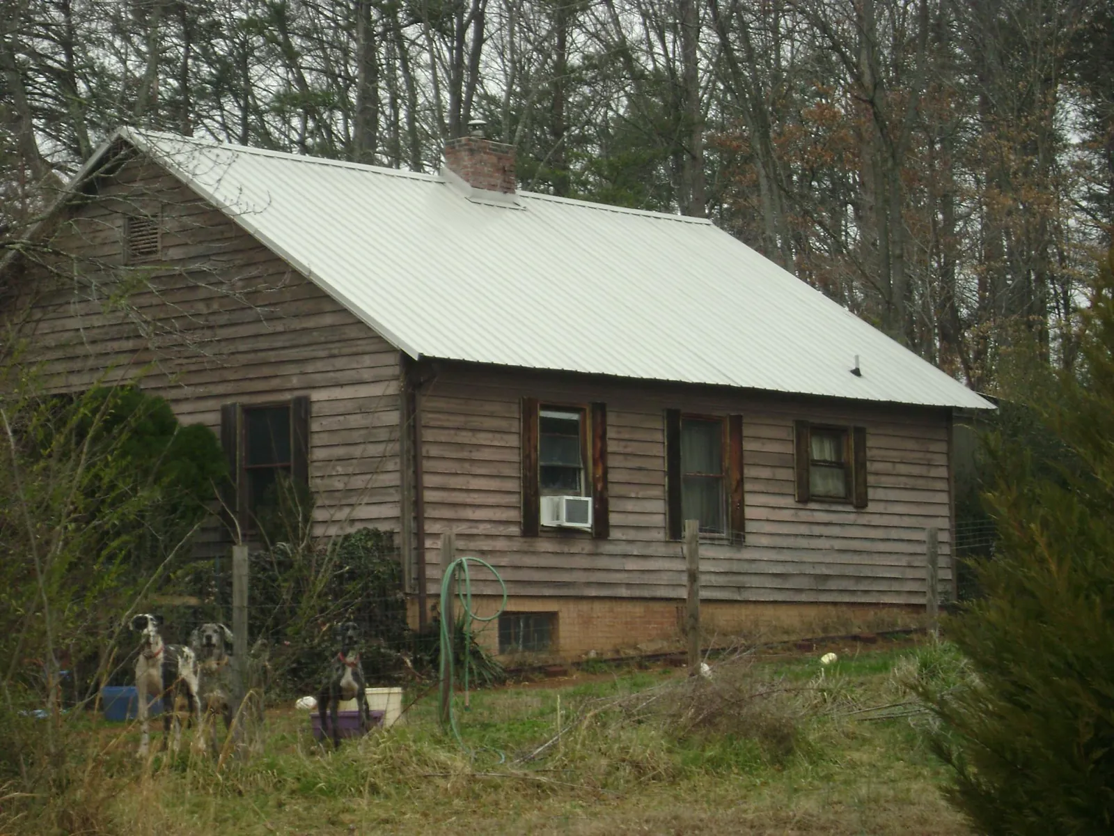 White metal roof on an old wood sided farmhouse, from a Metal Roof Installation job in Clover